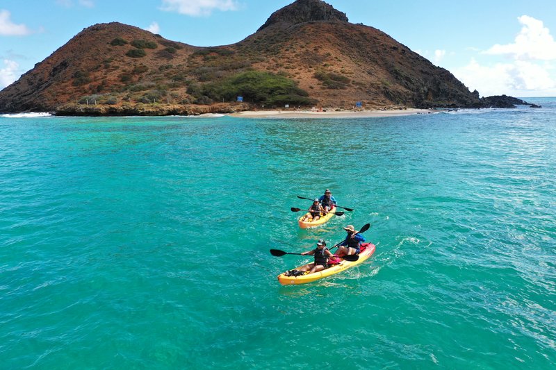 Kayakers paddling toward the Mokulua Islands with crystal clear blue water